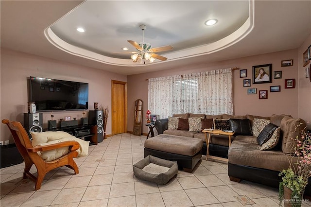 living area with light tile patterned floors, a raised ceiling, a ceiling fan, and recessed lighting