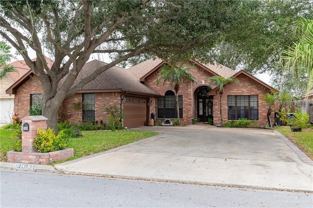 view of front of home featuring driveway, brick siding, roof with shingles, and an attached garage