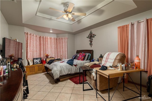 bedroom with a tray ceiling, a ceiling fan, and light tile patterned flooring