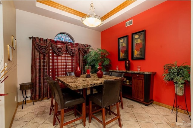 dining area featuring a tray ceiling, light tile patterned flooring, visible vents, and baseboards