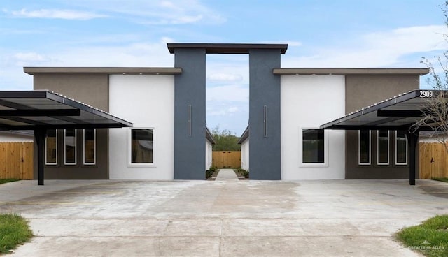 back of property with fence and stucco siding