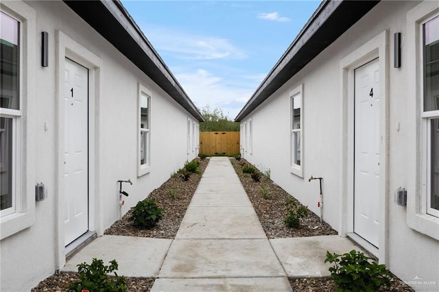 view of side of property with fence and stucco siding