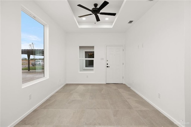 spare room featuring a tray ceiling, baseboards, a ceiling fan, and recessed lighting