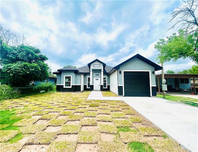 view of front facade with stucco siding, a front lawn, driveway, and a garage