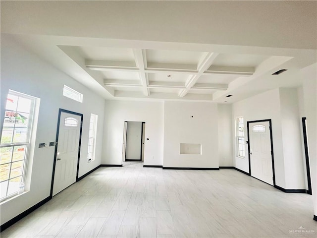 empty room with coffered ceiling, beamed ceiling, and baseboards