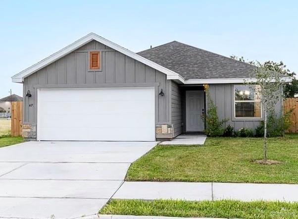 single story home featuring concrete driveway, a front yard, board and batten siding, and an attached garage