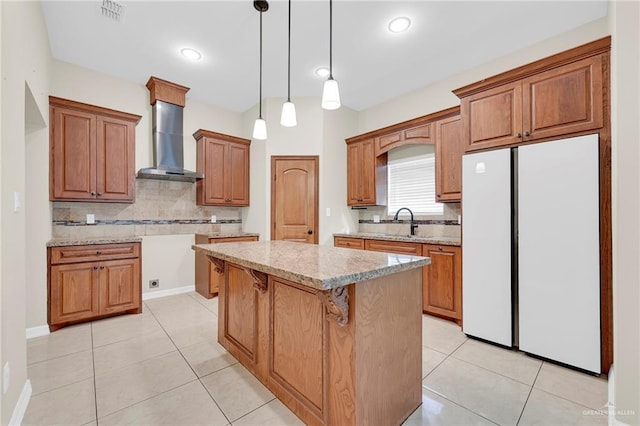 3120 La Puerta Ave, Edinburg, TX 78541 - kitchen with freestanding refrigerator, wall chimney exhaust hood, tasteful backsplash, brown cabinetry, and recessed lighting