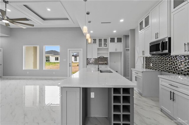 519 Oriole Dr, Los Fresnos, TX 78566 - kitchen with marble finish floor, a sink, stainless steel microwave, recessed lighting, and decorative backsplash