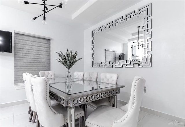 dining space featuring light tile patterned floors and a tray ceiling