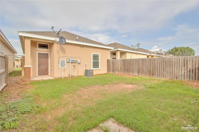 rear view of house featuring a yard and cooling unit