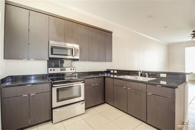 kitchen with sink, crown molding, appliances with stainless steel finishes, kitchen peninsula, and dark stone counters