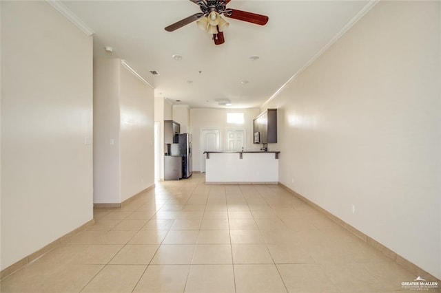 unfurnished living room featuring ceiling fan, ornamental molding, and light tile patterned floors