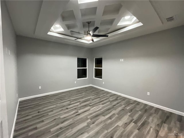unfurnished room featuring coffered ceiling, dark wood finished floors, visible vents, baseboards, and ceiling fan