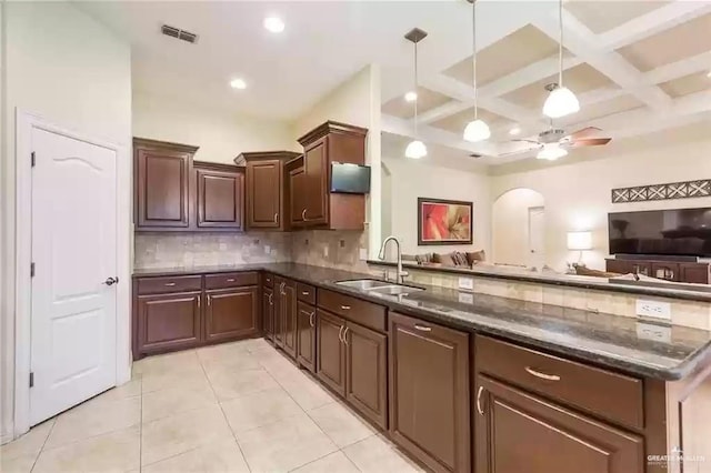 kitchen with sink, hanging light fixtures, beam ceiling, coffered ceiling, and kitchen peninsula