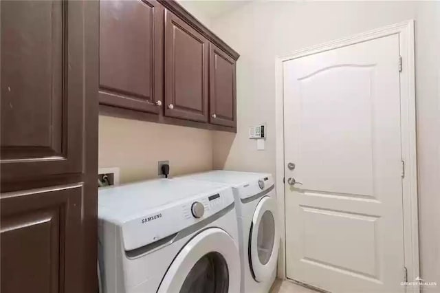 laundry room with cabinets and washing machine and clothes dryer