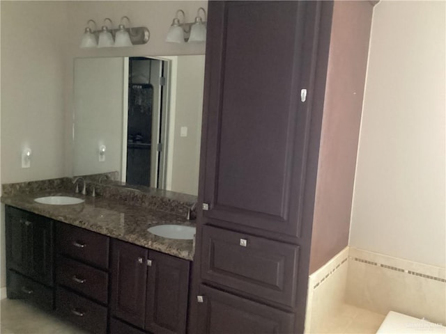 bathroom with tile patterned flooring, vanity, and a tub to relax in