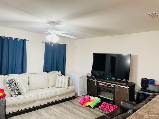 living room with hardwood / wood-style floors and ceiling fan