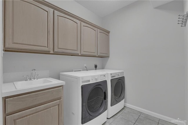 washroom featuring cabinets, light tile patterned floors, washing machine and dryer, and sink