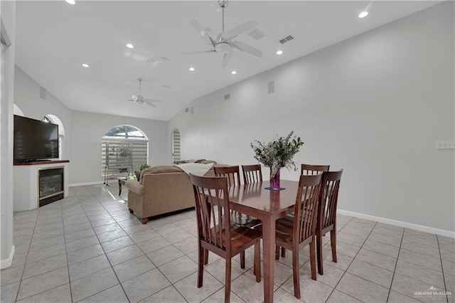 tiled dining room with ceiling fan and lofted ceiling