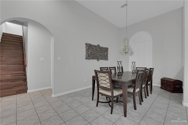 tiled dining space featuring vaulted ceiling and an inviting chandelier