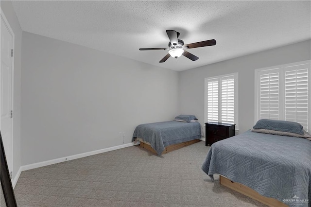 carpeted bedroom with ceiling fan and a textured ceiling