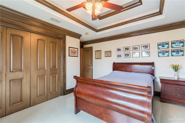 bedroom featuring a raised ceiling, ceiling fan, a closet, and ornamental molding