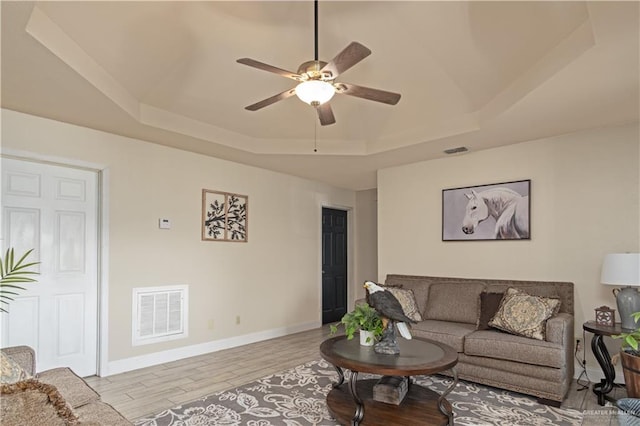 1309 El Camino Dr, Weslaco, TX 78599 - living room with a tray ceiling, a ceiling fan, wood finished floors, and baseboards