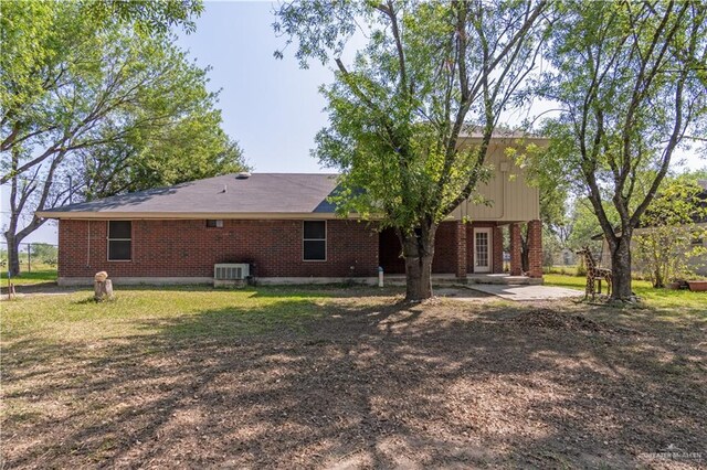 1309 El Camino Dr, Weslaco, TX 78599 - back of property featuring brick siding, a patio, and cooling unit