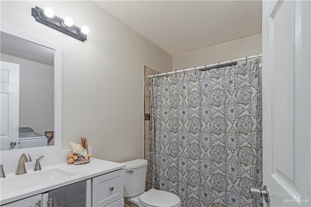 1309 El Camino Dr, Weslaco, TX 78599 - bathroom with vanity, toilet, a textured ceiling, washer / dryer, and a shower with curtain