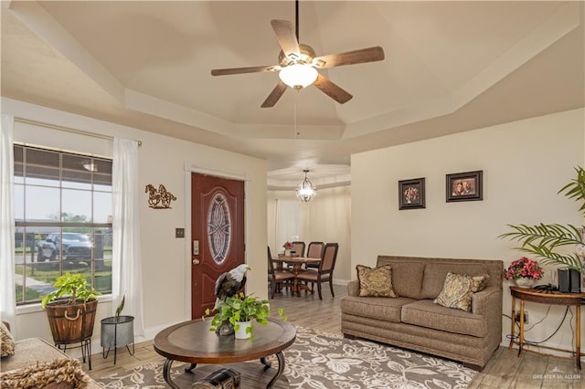 1309 El Camino Dr, Weslaco, TX 78599 - living room featuring a tray ceiling, a ceiling fan, light wood-style flooring, and baseboards