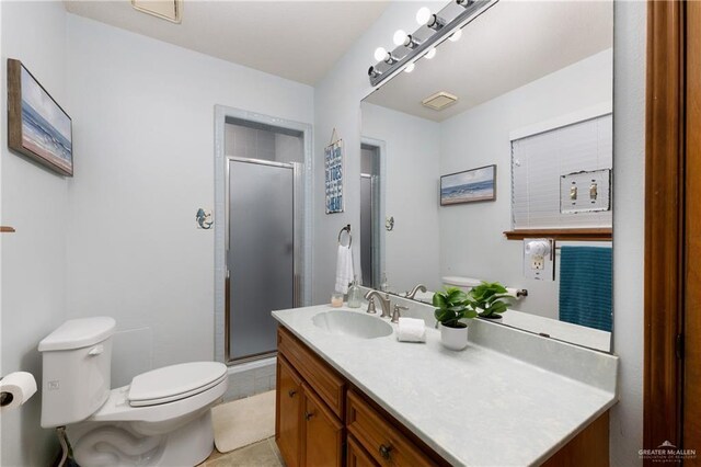 130 E Gardenia St, South Padre Island, TX 78597 - bathroom with vanity, a stall shower, visible vents, and toilet