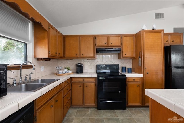 130 E Gardenia St, South Padre Island, TX 78597 - kitchen featuring black appliances, under cabinet range hood, a sink, lofted ceiling, and brown cabinets