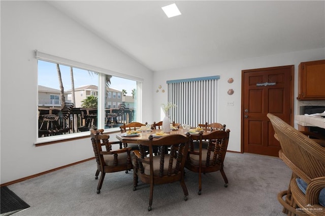 130 E Gardenia St, South Padre Island, TX 78597 - dining space with baseboards, vaulted ceiling, and light carpet