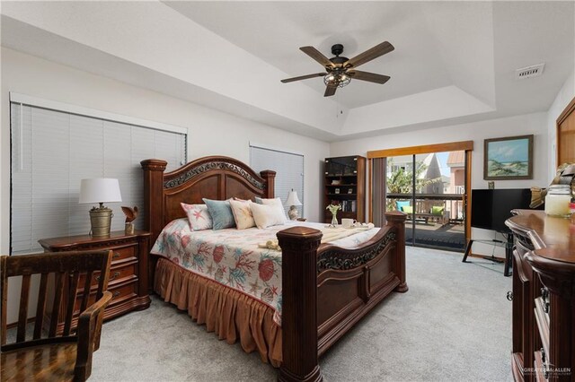 130 E Gardenia St, South Padre Island, TX 78597 - bedroom with visible vents, access to exterior, a tray ceiling, ceiling fan, and light colored carpet