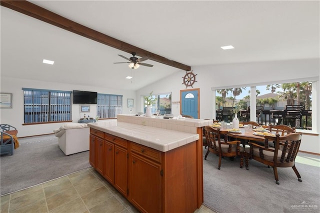 130 E Gardenia St, South Padre Island, TX 78597 - kitchen with lofted ceiling with beams, tile counters, open floor plan, ceiling fan, and light colored carpet