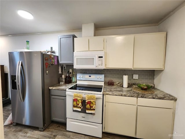 kitchen with dark hardwood / wood-style flooring, white appliances, tasteful backsplash, and crown molding