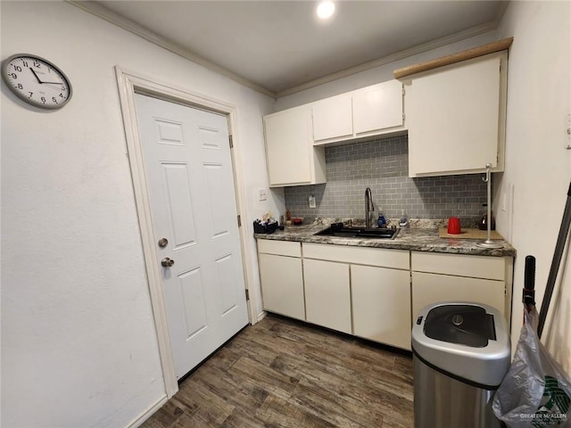 kitchen with dark hardwood / wood-style flooring, backsplash, crown molding, and sink