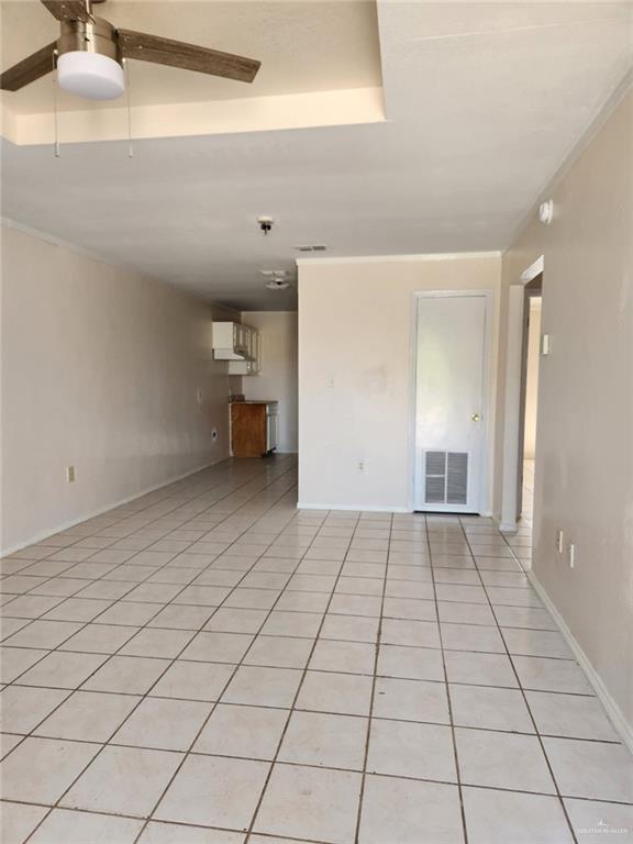 tiled spare room with ceiling fan