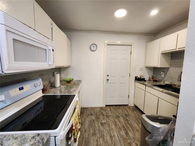 kitchen featuring decorative backsplash, dark hardwood / wood-style flooring, white appliances, crown molding, and white cabinets