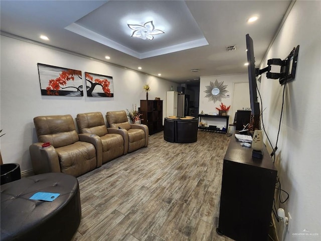 living room with hardwood / wood-style floors and a tray ceiling