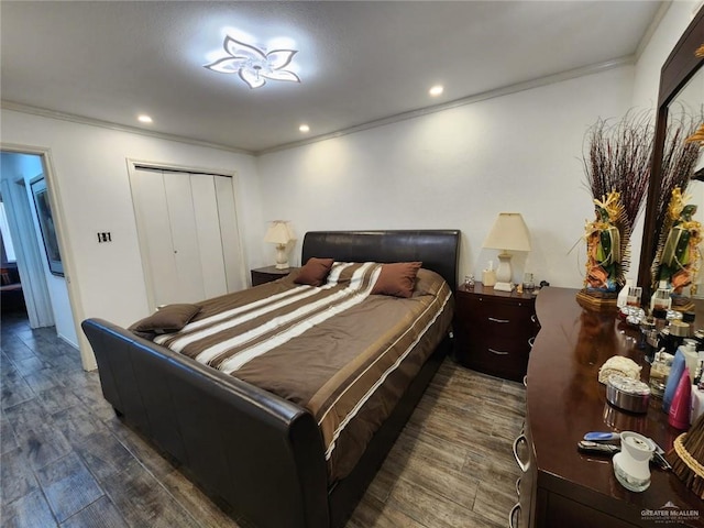 bedroom featuring dark hardwood / wood-style flooring, crown molding, and a closet