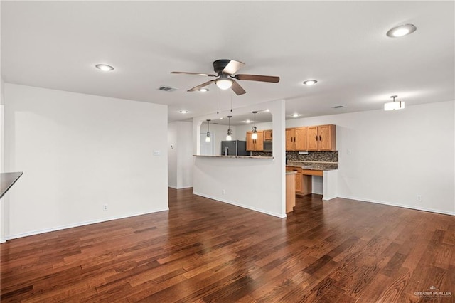 unfurnished living room with ceiling fan and dark hardwood / wood-style flooring