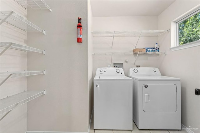 clothes washing area with separate washer and dryer and light tile patterned floors