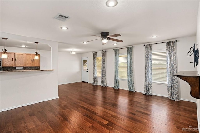 unfurnished living room featuring ceiling fan and dark hardwood / wood-style floors