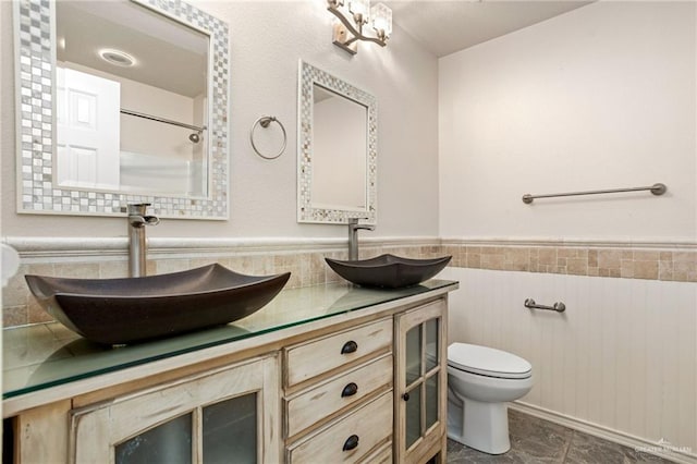 125 Katie Ct, Boerne, TX 78006 - full bathroom with tile walls, double vanity, wainscoting, and a shower