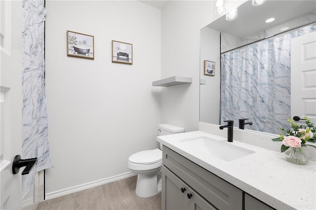 full bath with vanity, a shower with shower curtain, wood finished floors, baseboards, and toilet