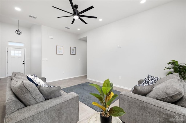 living area featuring recessed lighting, wood finished floors, visible vents, and baseboards