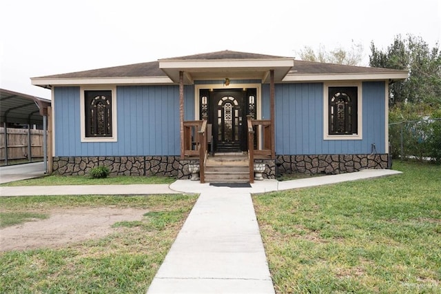 view of front of house with a carport and a front lawn