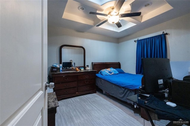 bedroom featuring ceiling fan and a raised ceiling