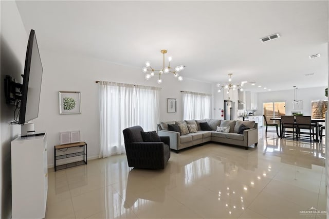 living area with a chandelier, light tile patterned floors, and baseboards